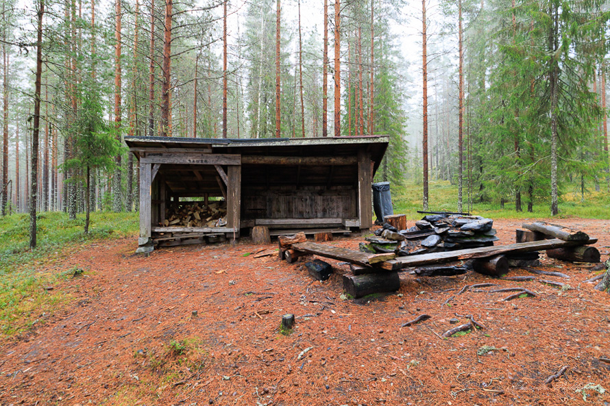 Metsässä sijaitseva laavu kuvattuna edestäpäin.